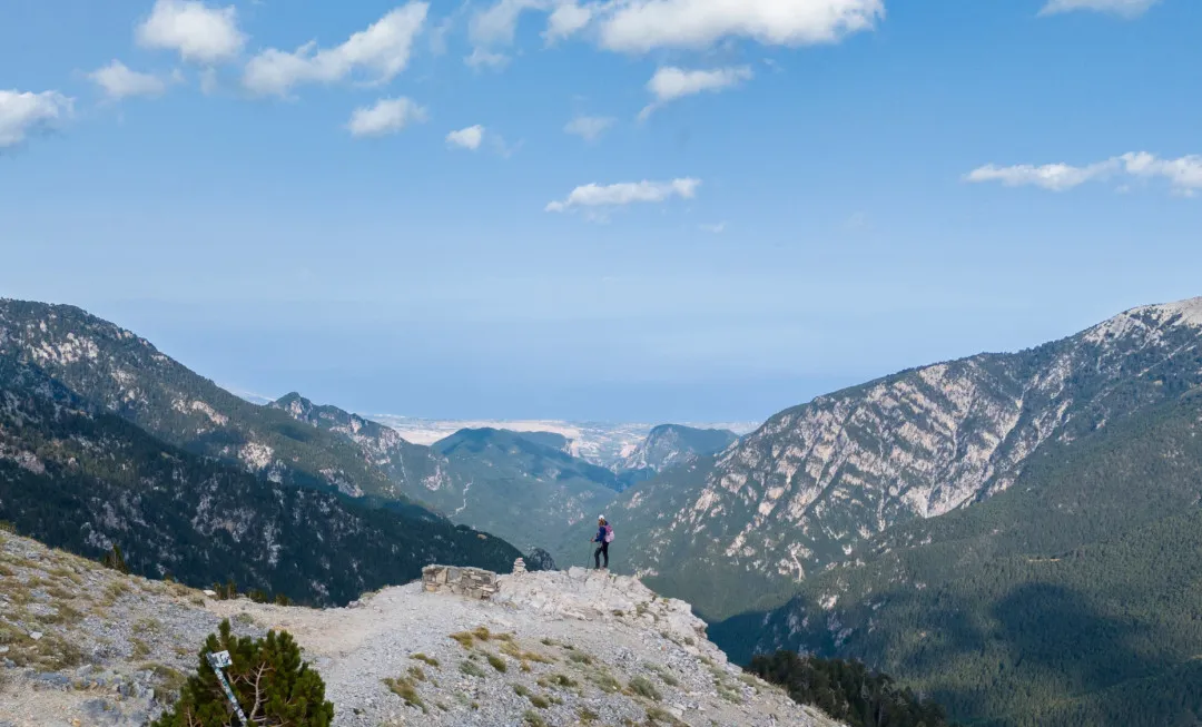 Person stood on rocky terrain with mountains behind