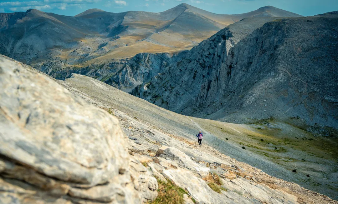Person hiking on rocky, mountainous terrain