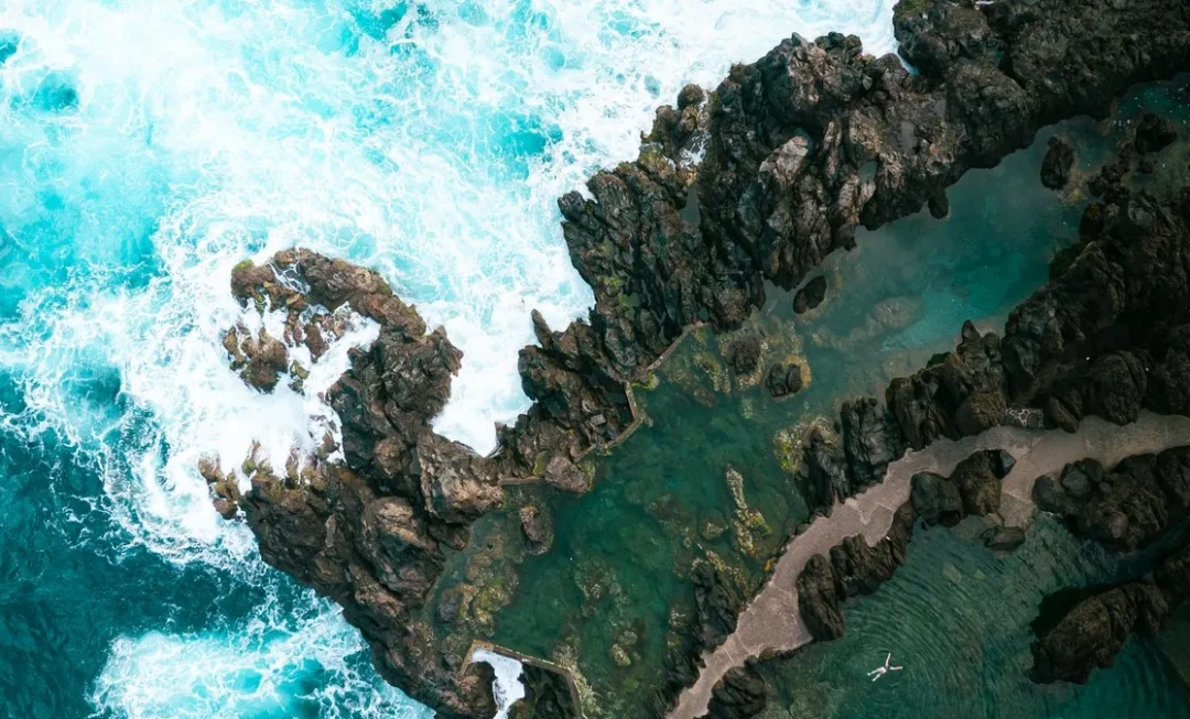 Aerial view of waves crashing against rocks