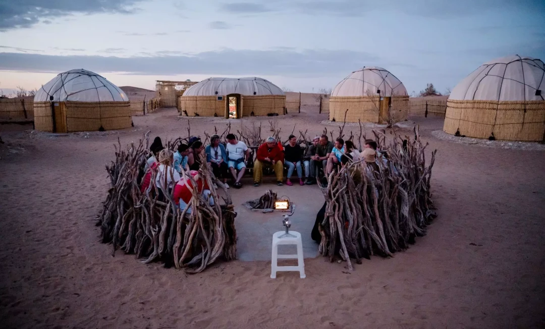 Participants gathered round and yurts in background