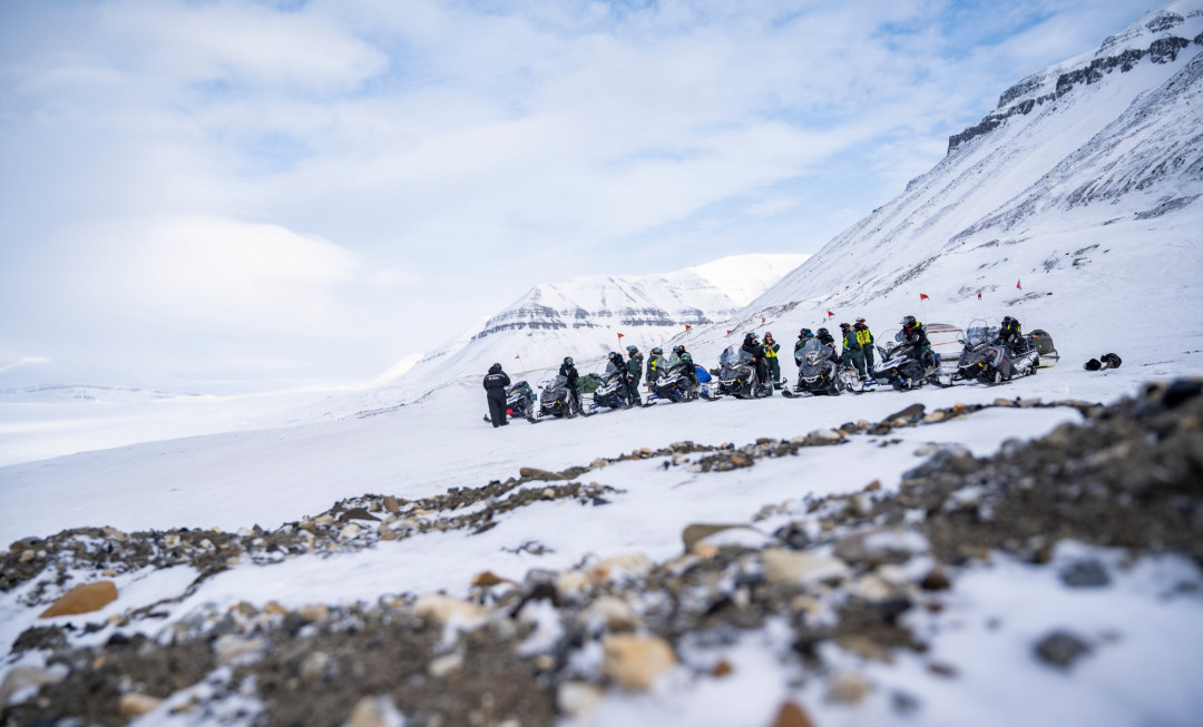 Participants stood on rocky and snow-covered terrain