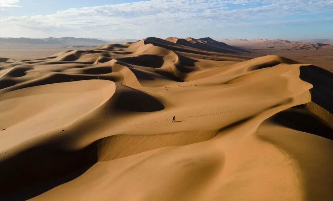 Smooth sand dunes under clear sky
