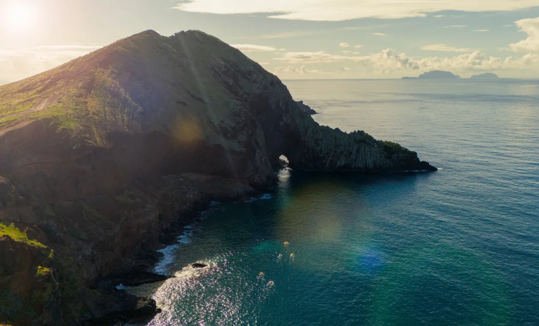Rocky cliff surrounded by bright, clear water