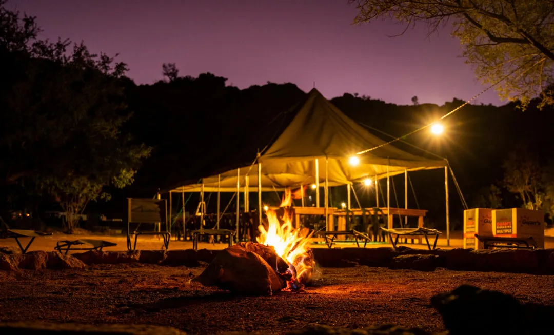 Fire, surrounded by chairs and gazebo behind