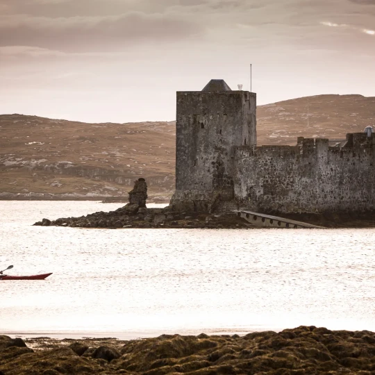 Participant kayaking past stone building
