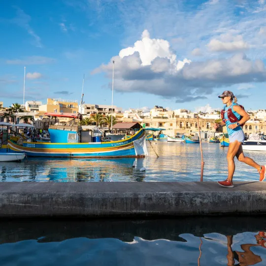Woman running past boats