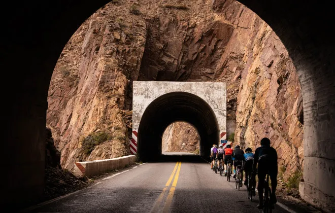 Cyclists riding through tunnel in mountain