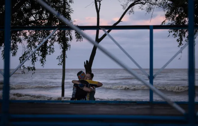 Participants hugging on a beach