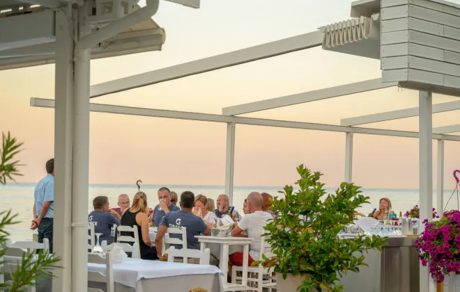 Participants having a meal in a restaurant at sunset