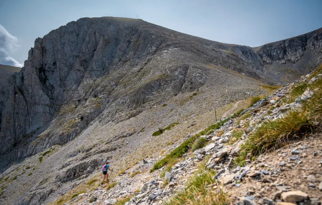 Woman walking up mountainous, rocky terrain