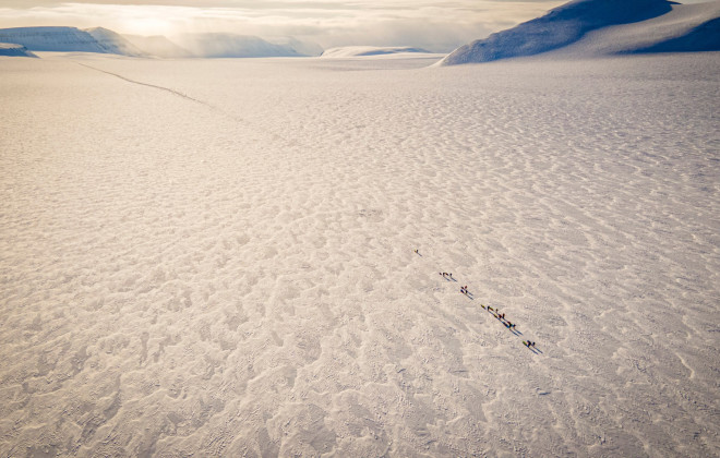 Aerial view of participants walking across frozen ground