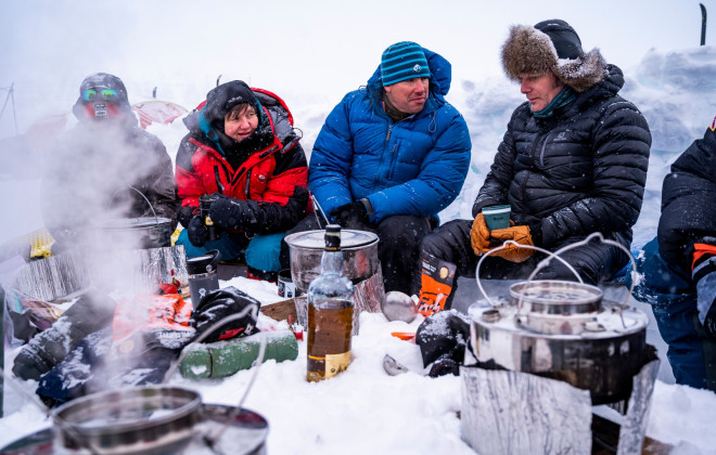 Participants sat in snow and gathered around cooking stoves