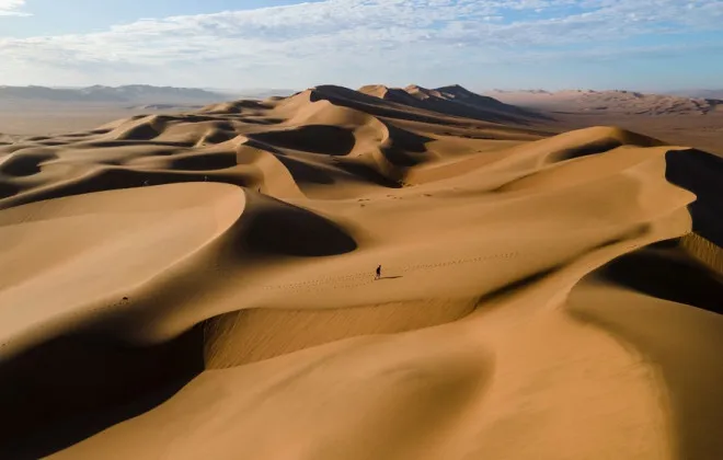 Smooth sand dunes under clear sky