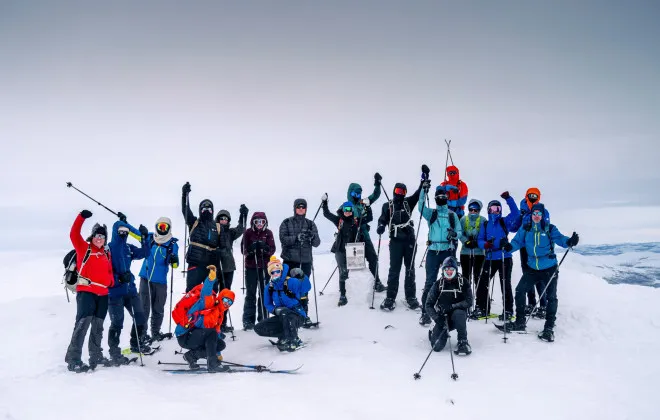 A group of event participants with skis who are cheering