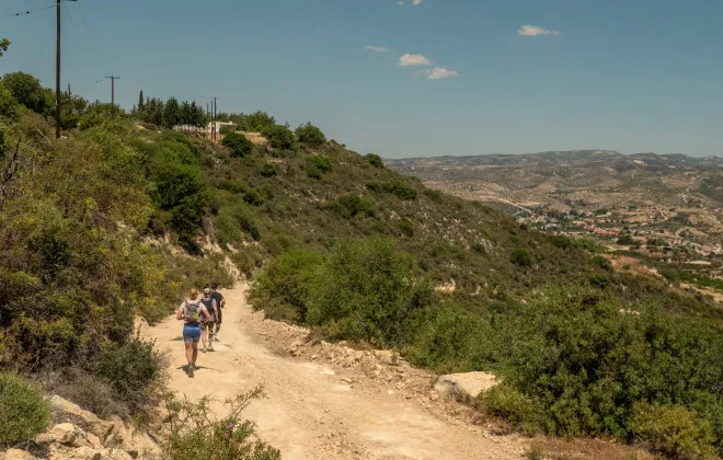 Participants running along a rocky road with greenery either side of them