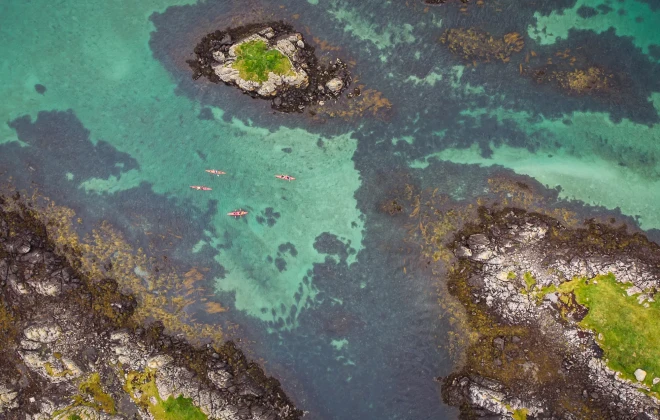 Aerial view of participants kayaking through clear, blue water
