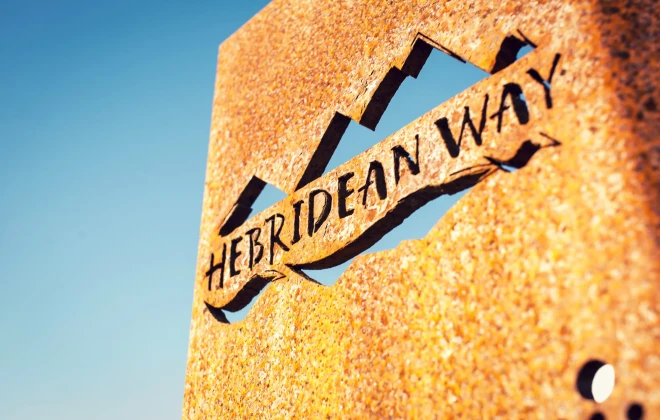 'Hebridean Way' rusty sign and bright, blue sky behind