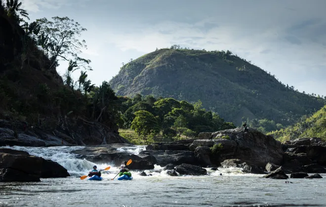 Participants rafting with mountain behind