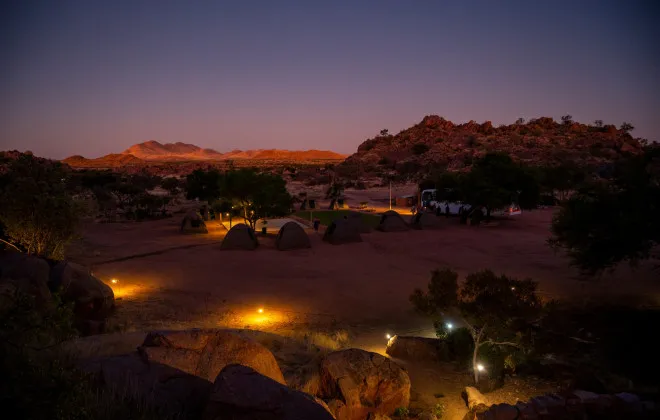 Campsite at night, surrounded by rocky terrain