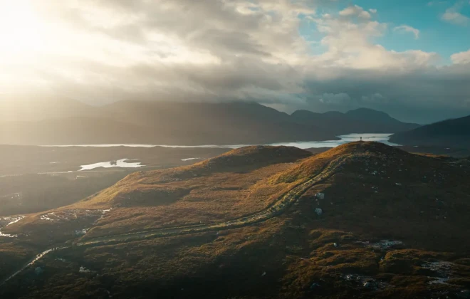 Path through hills and water in the distance