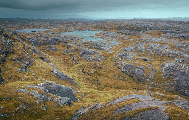 Rocky, grassy terrain with water in the distance