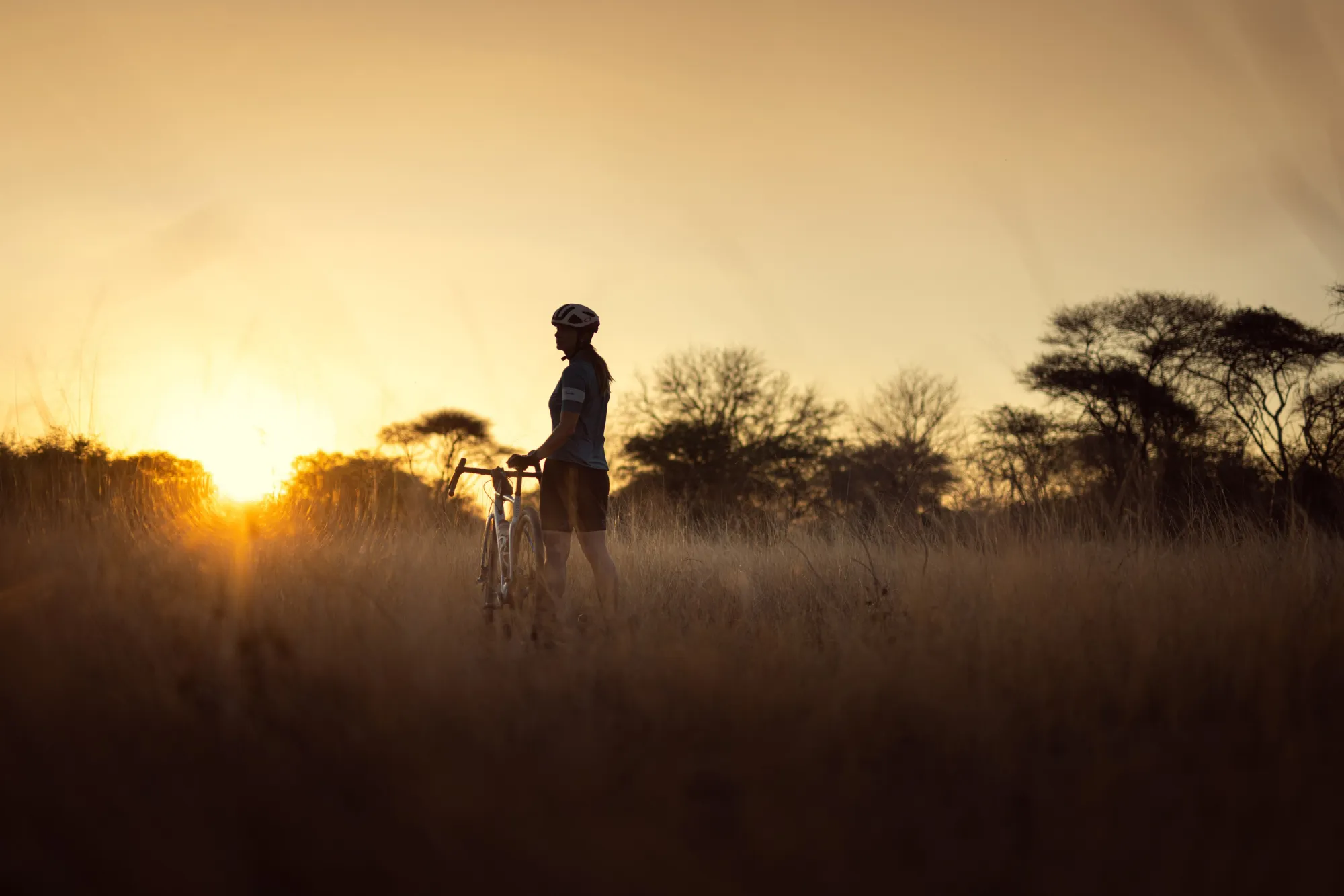 Woman stood on grass with bike