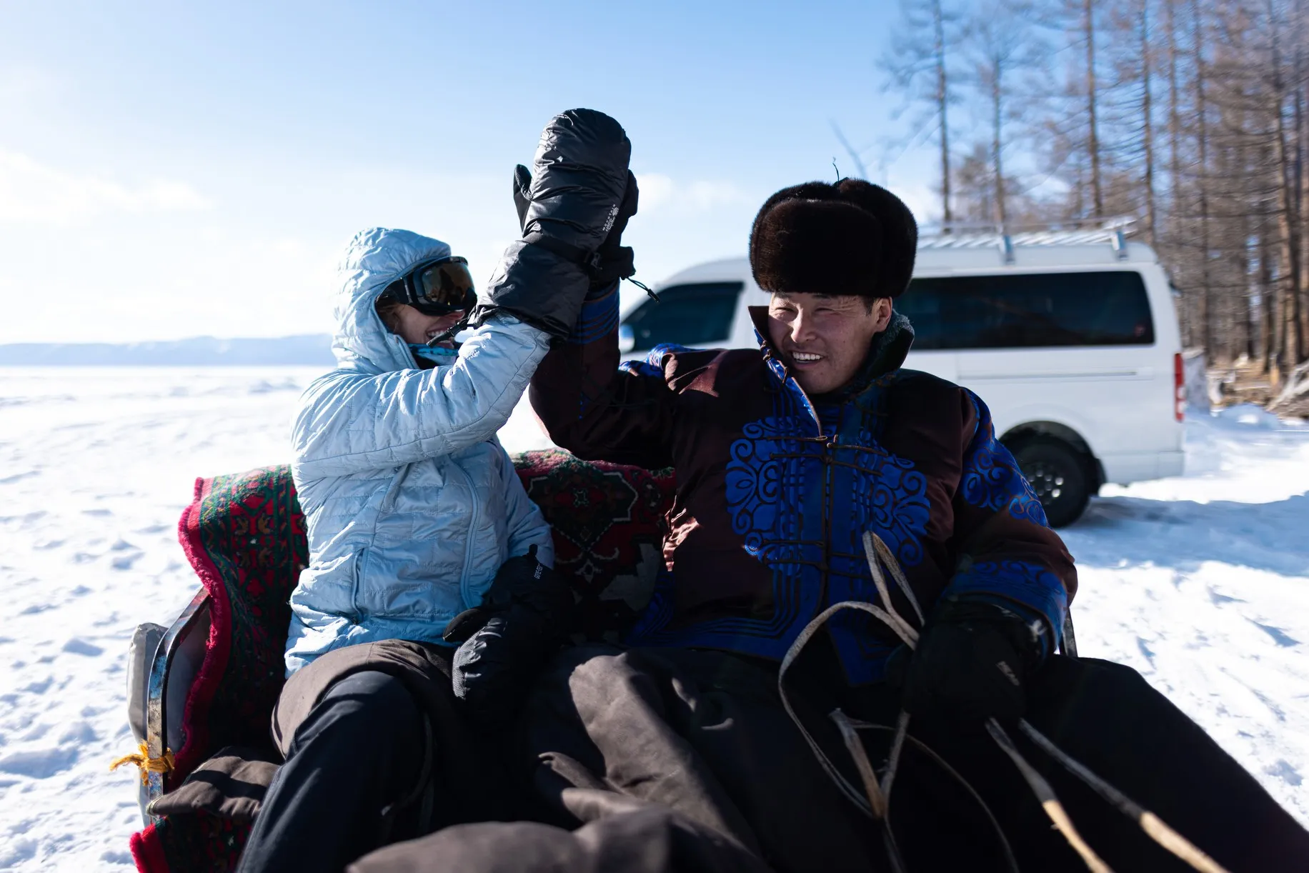 Man and woman high-fiving in a snowy setting