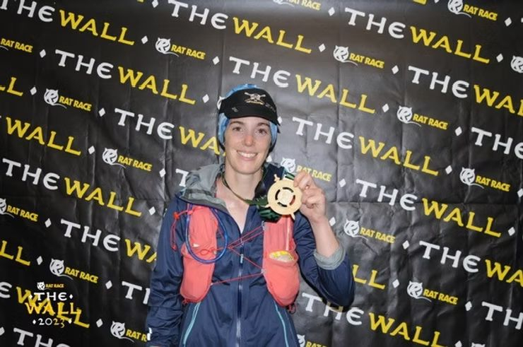 Woman smiling and holding medal