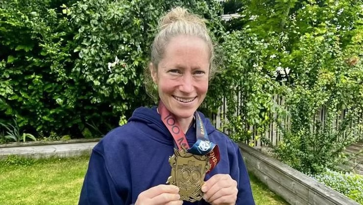 Woman smiling and holding medal